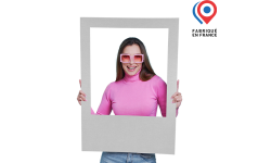 Femme tenant le cadre photobooth en carton en situation réelle, cadre blanc vierge sans personnalisation, mettant en avant la fabrication française et l’utilisation pratique lors d’événements