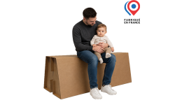 Banc en carton ondulé avec homme et son enfant assis dessus, démontrant l’usage pratique et le confort du mobilier carton